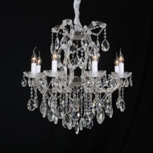 A modern 6-light chandelier with glass globes and a polished stainless steel frame in a minimalist dining room.