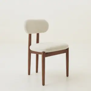 Mid-century modern solid ash wood dining chair in black oak and walnut finishes with white bouclé upholstery.