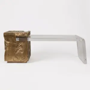Luxury transparent resin tea table with sculptural bronze-tone pedestal for modern hotel lobby.
