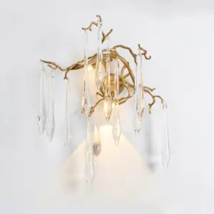 Gold metal branch-shaped wall sconce with hanging clear crystal icicles.