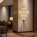 A wide, cinematic view of a luxury hotel suite featuring a modern tripod floor lamp with a tiered fabric shade.