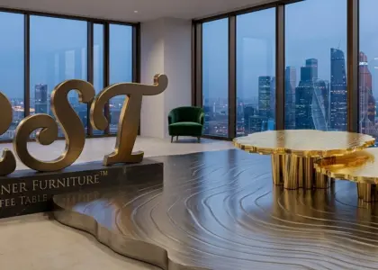 Gold-plated nested coffee table with tree-ring engraved metal floor and brass RST logo at dusk, overlooking a city skyline through large windows.