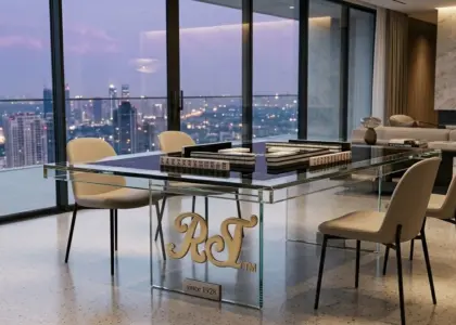 RST Luxury Glass Mahjong Table featuring a minimalist tempered glass design with a black playing surface in a high-end skyscraper penthouse at twilight.