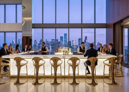 A row of RST Luxury Gold Sculptural Bar Stools with organic metallic frames at a glowing marble bar in a high-end skyscraper sky lounge at twilight.