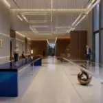 A luxury hotel lobby featuring a long RST Luxury Gradient Acrylic Console Table with a deep blue to clear transition, set against modern wood and concrete architectural elements.