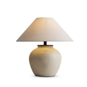 Rustic sand textured ceramic table lamp with wide conical linen shade for luxury hotel decor.