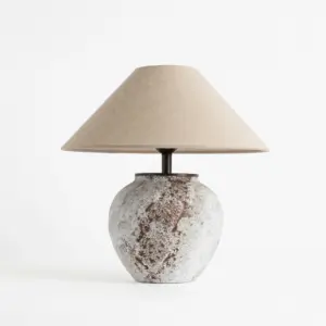 Artisanal distressed white and brown speckled ceramic table lamp with conical linen shade for luxury hotel decor.