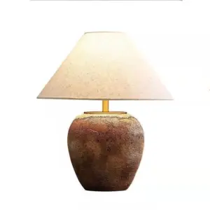 Volcanic earth textured brown ceramic table lamp with linen shade for luxury hotel projects.