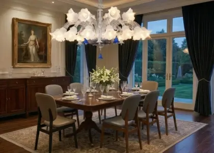 A high-resolution image of a grand crystal chandelier hanging over a dining table with a mix of wood and leather chairs. The table is set for dinner, and a large painting in a gold frame is on the wall.