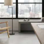 A hand-woven paper cord lounge chair by RST in a modern architectural office overlooking a city skyline, representing high-end contract furniture solutions.
