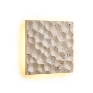 Customizable luxury textured square wall sconce made of natural yellow travertine with warm LED relief lighting for hotel interiors.