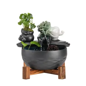 Artisanal PiXiu Guardian Zen Ceramic Water Fountain with kinetic water wheel, green plant, and solid wood stand.