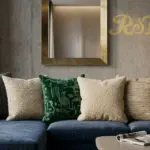Luxury bespoke artisan textural throw pillows by RST on a navy velvet sofa in a modern commercial hotel lobby setting.